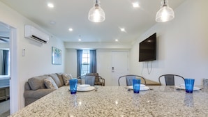 A modern kitchen with granite countertops, a dining table, and blue glassware. - Community Pool Access: Rehoboth Beach Unit! (Rehoboth Beach)