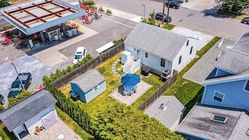 Houses with attached garages and varied roof styles are nestled behind a well-maintained fence.