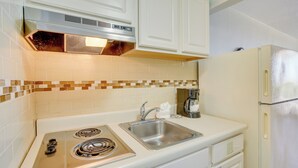 A kitchen with a stove, sink, and refrigerator. - Ocean-view Jersey Shore Condo: Walk to Beach! (Wildwood Crest)