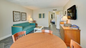 A compact living space with a dining table, sofa, and kitchenette. - Ocean-view Jersey Shore Condo: Walk to Beach! (Wildwood Crest)