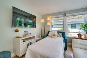 A bedroom with a bed, dresser, and a large window. - Charming + Updated Villas Home w/ Backyard! (Villas)