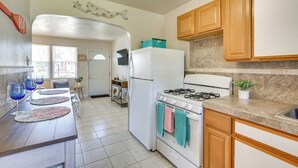 A kitchen with a refrigerator, stove, and wooden cabinets.