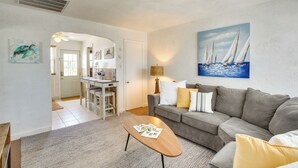 A living room with a grey sofa, a wooden coffee table, and a painting of sailboats on the wall. - Wildwood Crest Getaway w/ Deck, Walk to Beach! (Wildwood Crest)