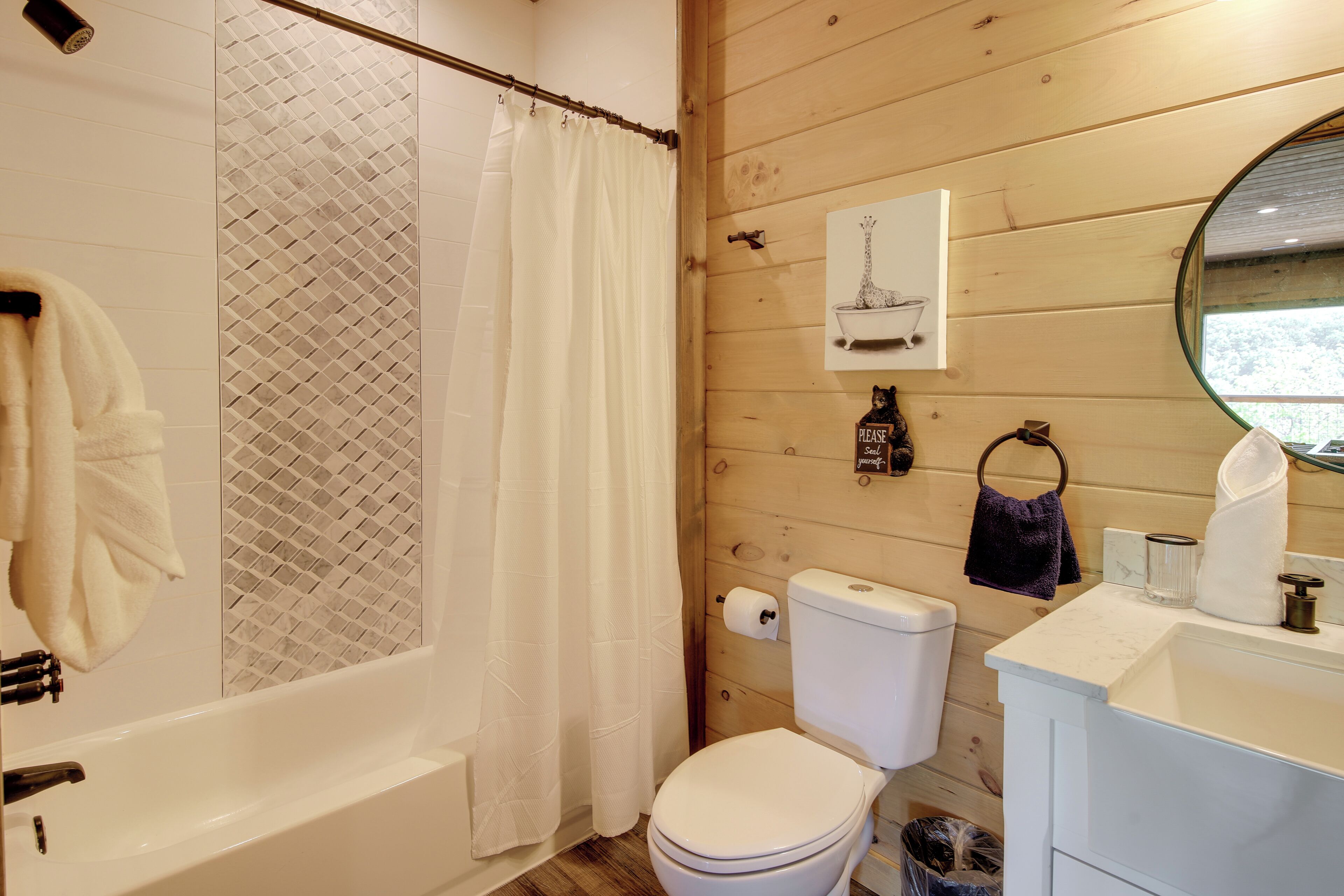 A bathroom with a bathtub, toilet, and sink.