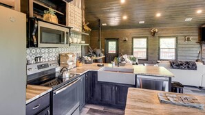 A modern kitchen with a large island, built-in appliances, and a cozy seating area with a fireplace.