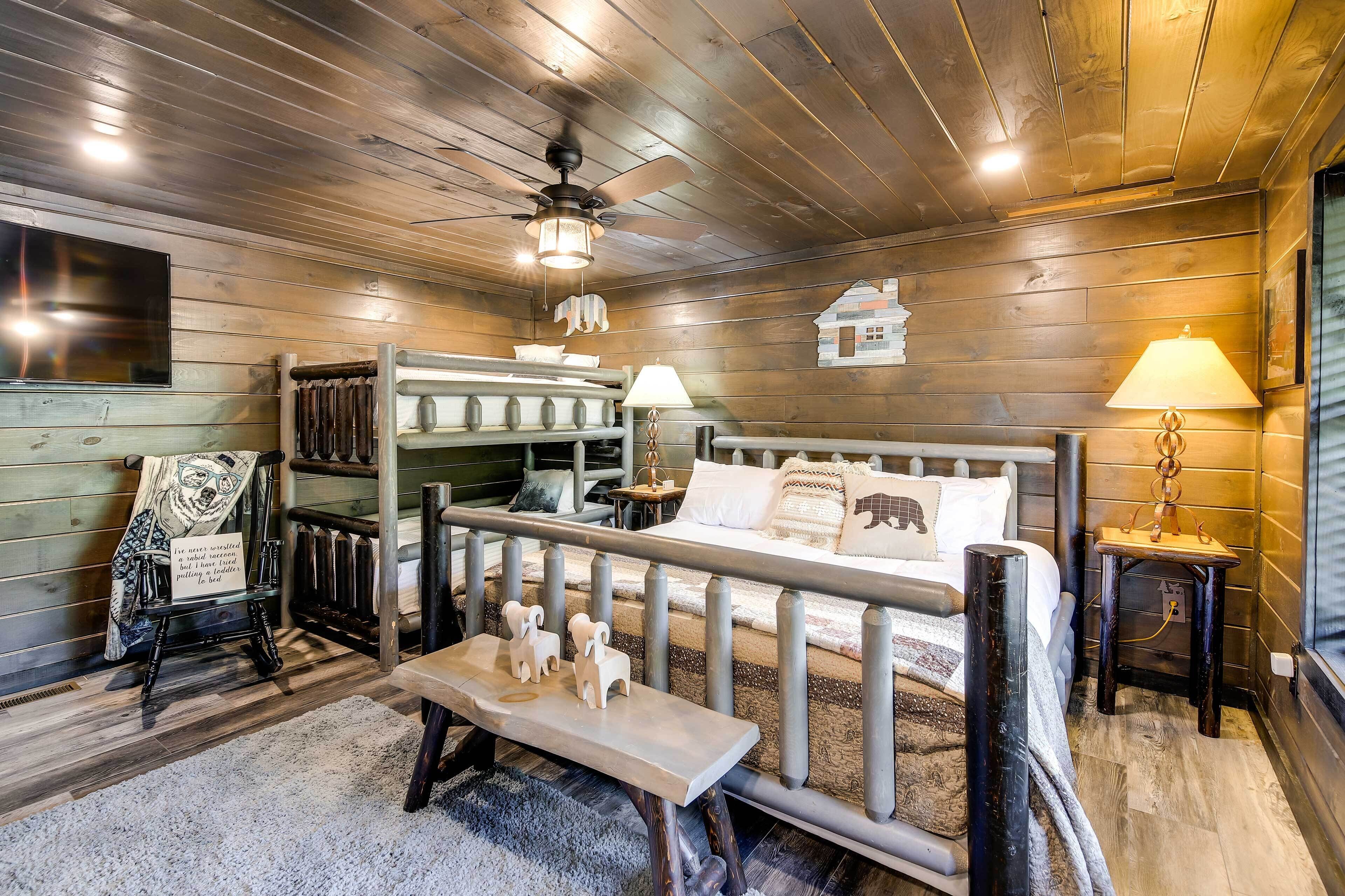 A cozy cabin interior with a bunk bed, a wooden bench, and a small table with a lamp.