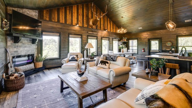 A spacious living area with a fireplace, leather sofas, and a large TV.