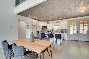 A modern kitchen with white cabinets, a wooden dining table, and black chairs. - Luxe Sevierville Home w/ Deck Near Pigeon Forge! (Sevierville)