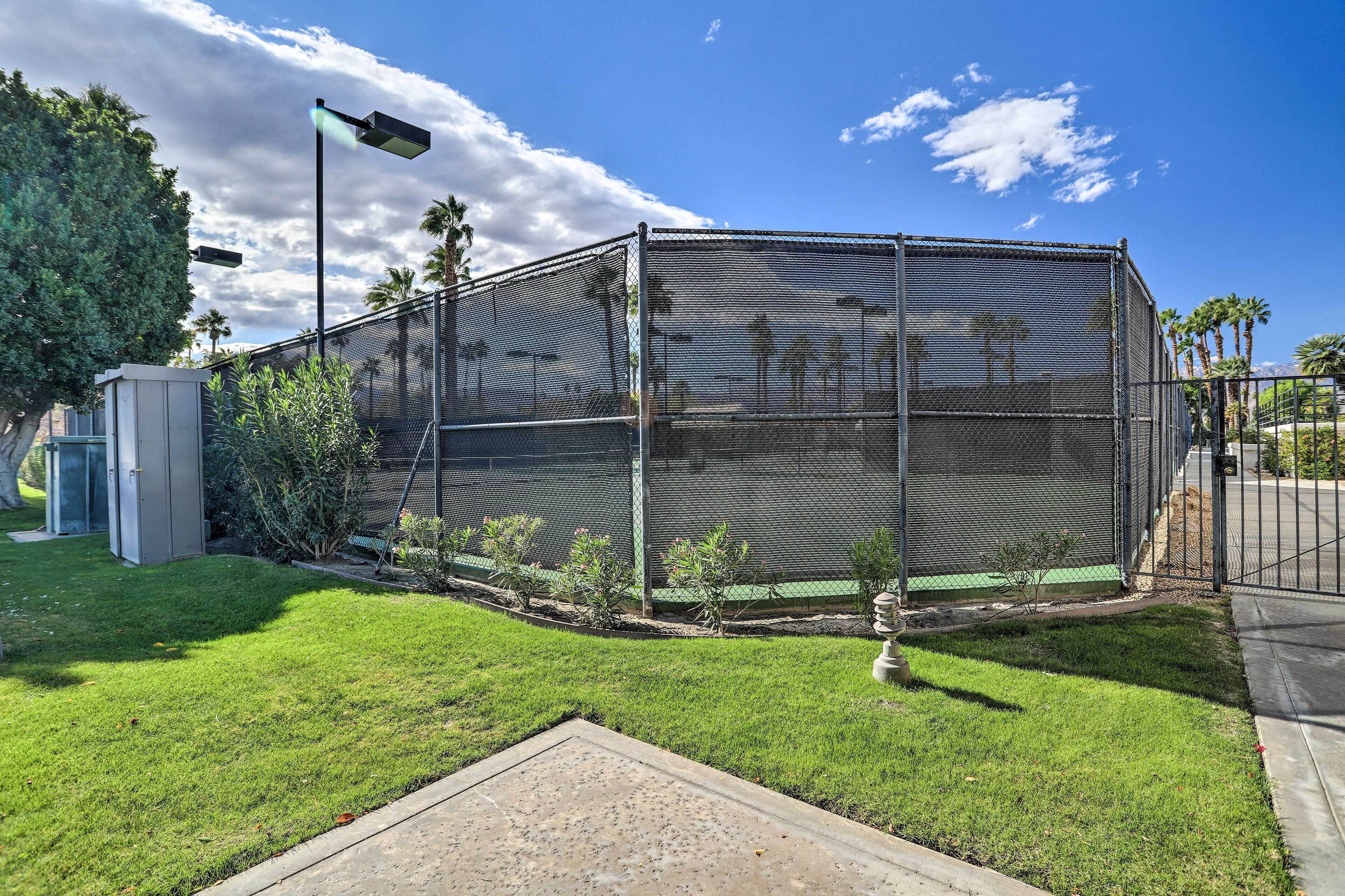 A fenced outdoor area with a grassy lawn, a small utility shed, and a street lamp.