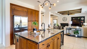 Una cocina moderna con armarios de madera, un refrigerador de acero inoxidable y una isla central con lavaplatos.
