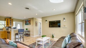 A modern living room with a brown leather sofa, a white coffee table, and a patterned rug. - North Lauderdale Vacation Rental: 8 Mi to Beach! (North Lauderdale)