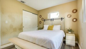 A bedroom with a bed, bedside tables, a bench, and decorative wall elements. - North Lauderdale Vacation Rental: 8 Mi to Beach! (North Lauderdale)