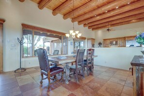 A dining area with a wooden table, chairs, and a chandelier. - Spacious Santa Fe Vacation Rental ~ 5 Mi to Town! (Santa Fe)