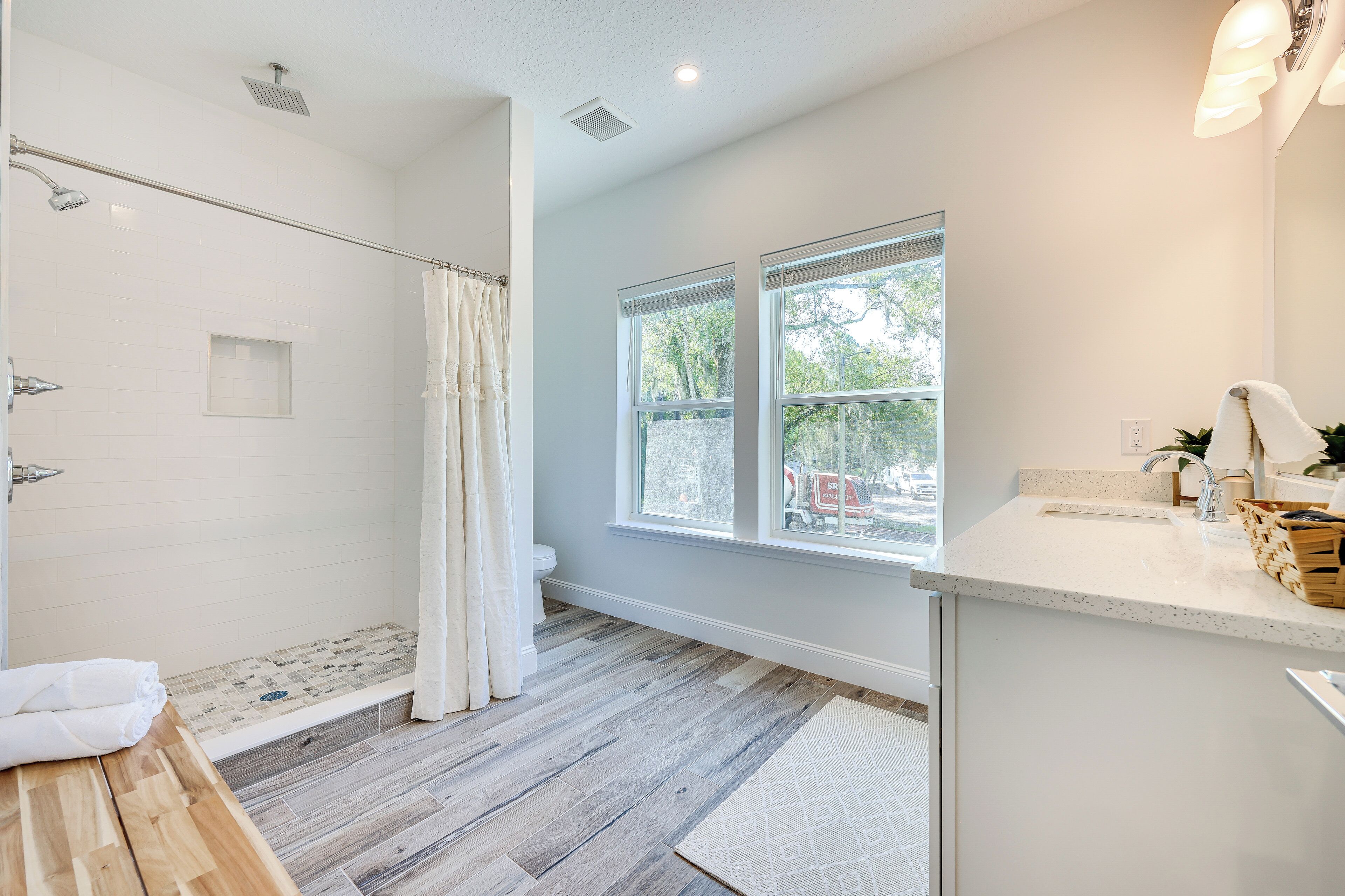 A modern bathroom with a shower, toilet, and sink.