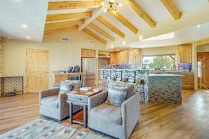 A spacious living area with a wooden ceiling, a kitchen with a stone backsplash, and a dining area with a table and chairs. - Scenic Santa Fe Vacation Rental w/ Views + Hot Tub (Santa Fe)