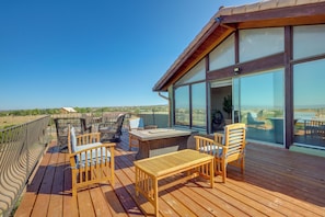 A wooden deck with outdoor furniture, large windows, and a view of the landscape. - Scenic Santa Fe Vacation Rental w/ Views + Hot Tub (Santa Fe)