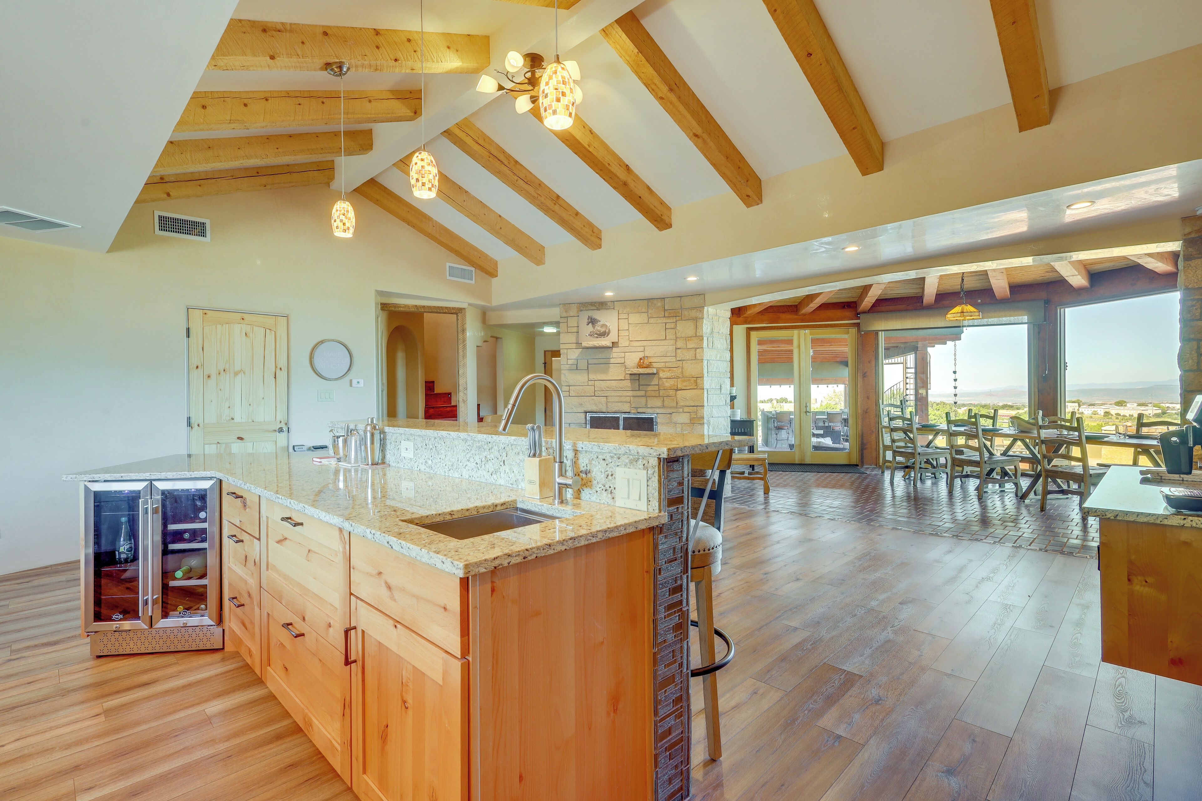 A spacious kitchen with wooden cabinets, a large island, and a stone accent wall.