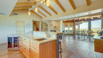 A spacious kitchen with wooden cabinets, a large island, and a stone accent wall.