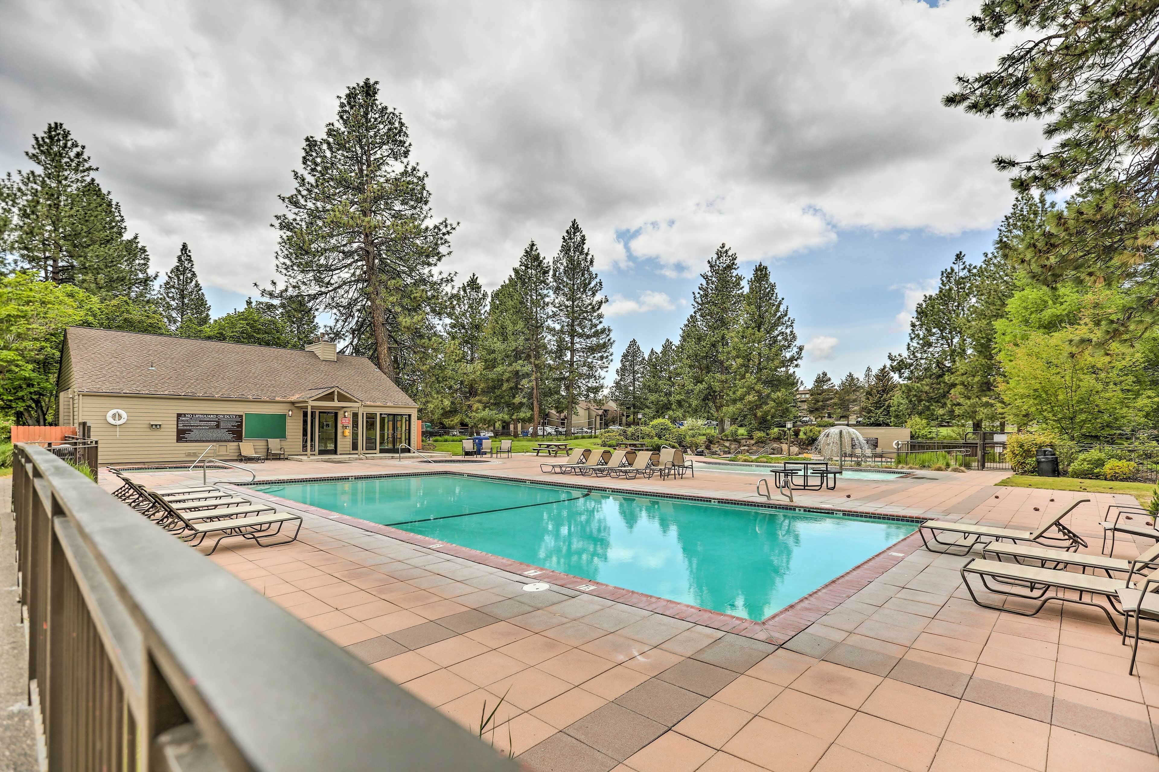 A swimming pool with lounge chairs and a building with a sign.