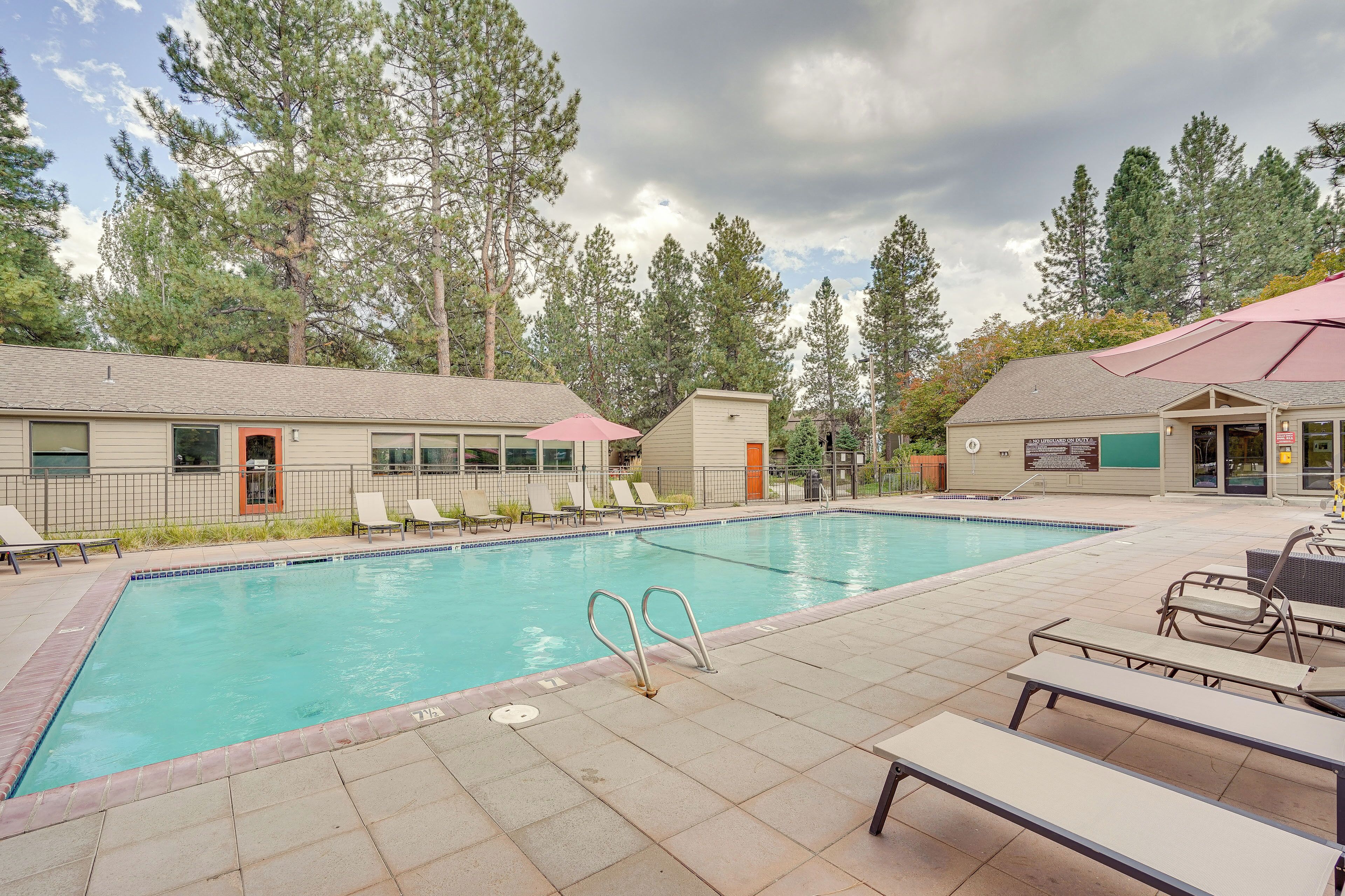 A swimming pool with lounge chairs and a building with a sign.