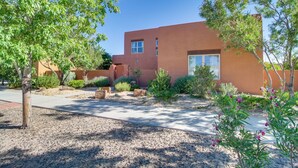 A modern building with a flat roof, large windows, and a paved courtyard with gravel and plants. - Pet-friendly Albuquerque Vacation Escape! (Albuquerque)