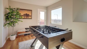 A foosball table in a room with a potted plant, a painting, and a window. - Pet-friendly Albuquerque Vacation Escape! (Albuquerque)