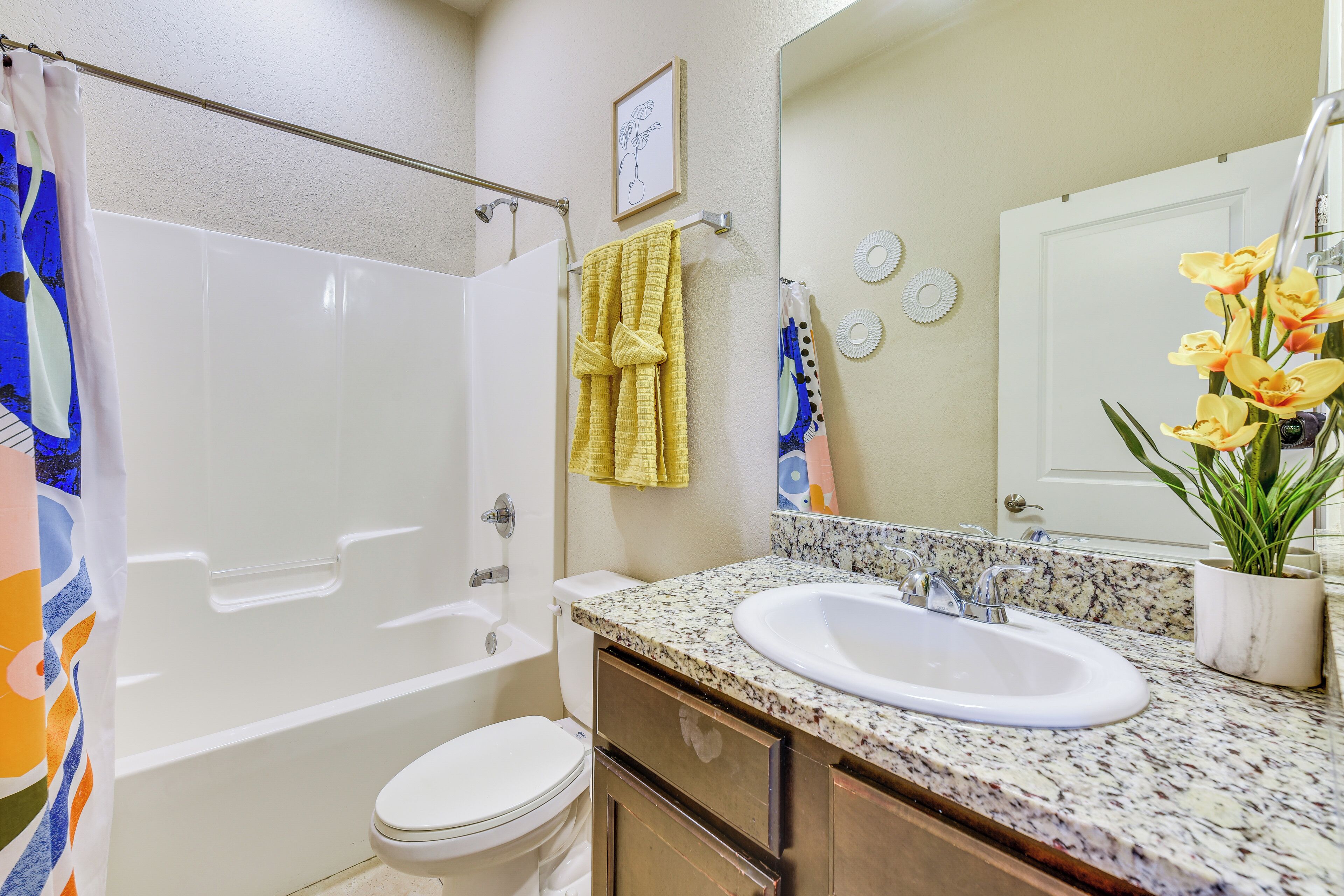 Une salle de bain avec une baignoire, des toilettes, un lavabo et un miroir.