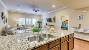 A spacious kitchen with granite countertops, stainless steel sinks, and wooden cabinets. - Miramar Beach Condo w/ Pool - Walk to Beach! (Miramar Beach)