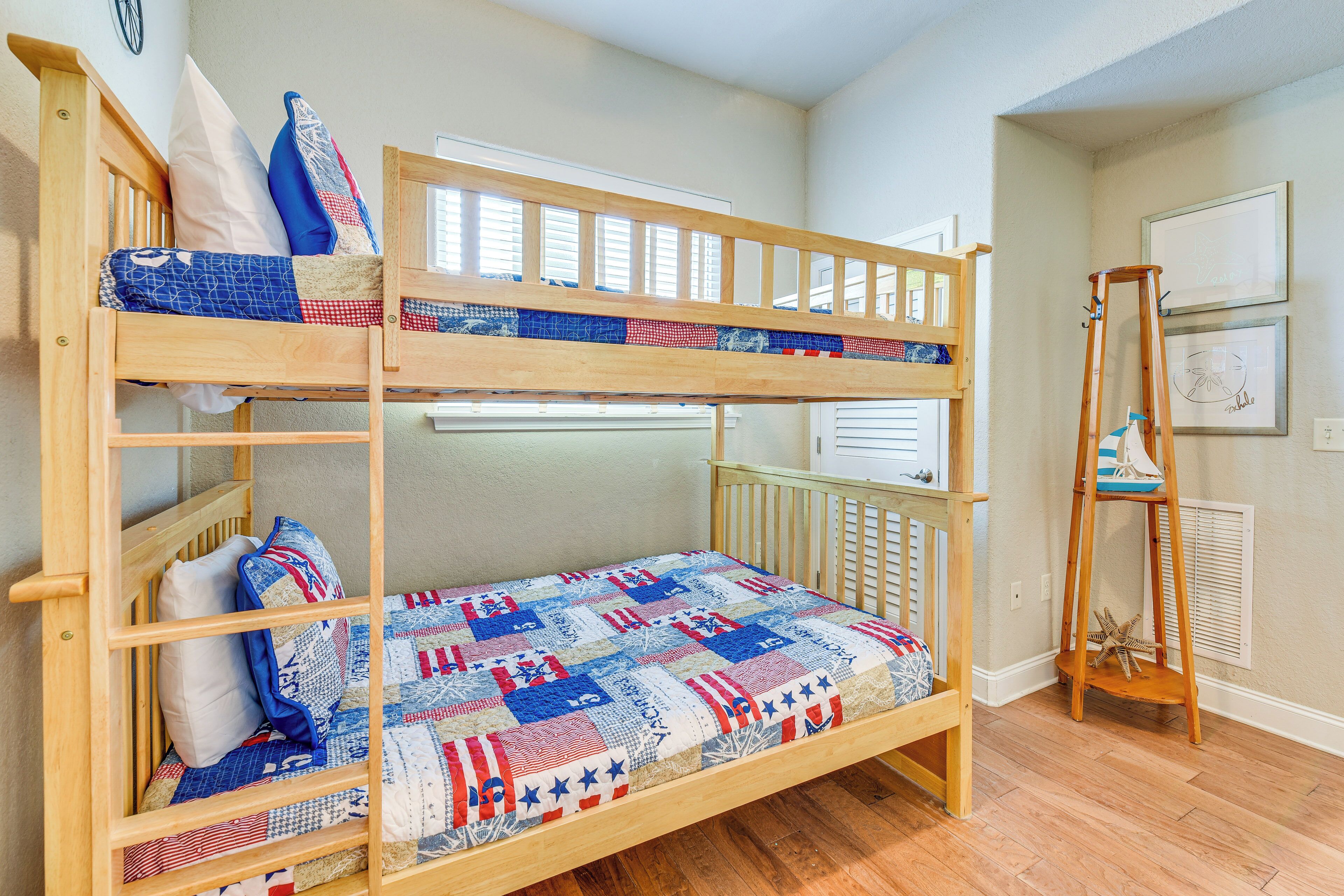 A bunk bed with a quilt, wooden ladder, and a starfish decoration.