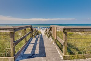 A wooden boardwalk leading to a beach with umbrellas and people. - Miramar Beach Rental w/ Pool Access & Golf Course! (Miramar Beach)