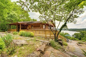 A wooden cabin with a porch, stone pathway, and a view of a lake. - Eagle Rock Gem on Table Rock Lake w/ Decks & Grill (Eagle Rock)