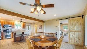 A spacious kitchen with wooden cabinets, a central island, and a dining area with a round table and chairs. - Eagle Rock Gem on Table Rock Lake w/ Decks & Grill (Eagle Rock)