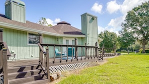 Une maison dotée d’une terrasse en bois, d’un patio couvert et d’une cour clôturée.