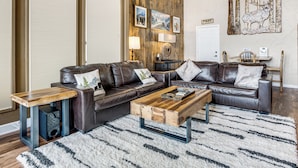 A living room with a brown leather sofa, a wooden coffee table, and a white shag rug. - Hot Tub Relaxation: Luxe Summit Gem w/ Mtn Views (Dillon)