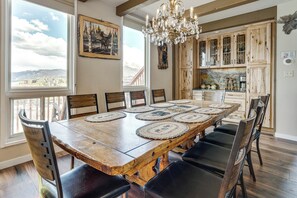 A dining area with a wooden table, chairs, and a chandelier. - Hot Tub Relaxation: Luxe Summit Gem w/ Mtn Views (Dillon)