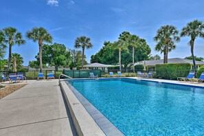 A swimming pool with blue lounge chairs and palm trees in the background. - Sunny Sarasota Oasis w/ Private Screened Lanai (Sarasota)