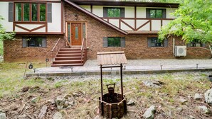 Una casa de dos pisos con fachada de ladrillo, una escalera de madera y una puerta principal.