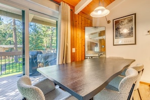 A dining area with a large table and chairs, a wooden ceiling, a large window with curtains, and a framed picture on the wall. - Mammoth Lakes Vacation Rental: 1 Mi to Ski Area! (Mammoth Lakes)