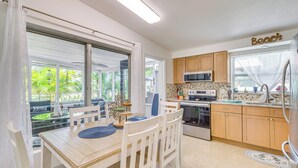 A kitchen with wooden cabinets, a microwave, and a refrigerator. - Hot Tub & Gas Grill: Port Richey Retreat (Port Richey)