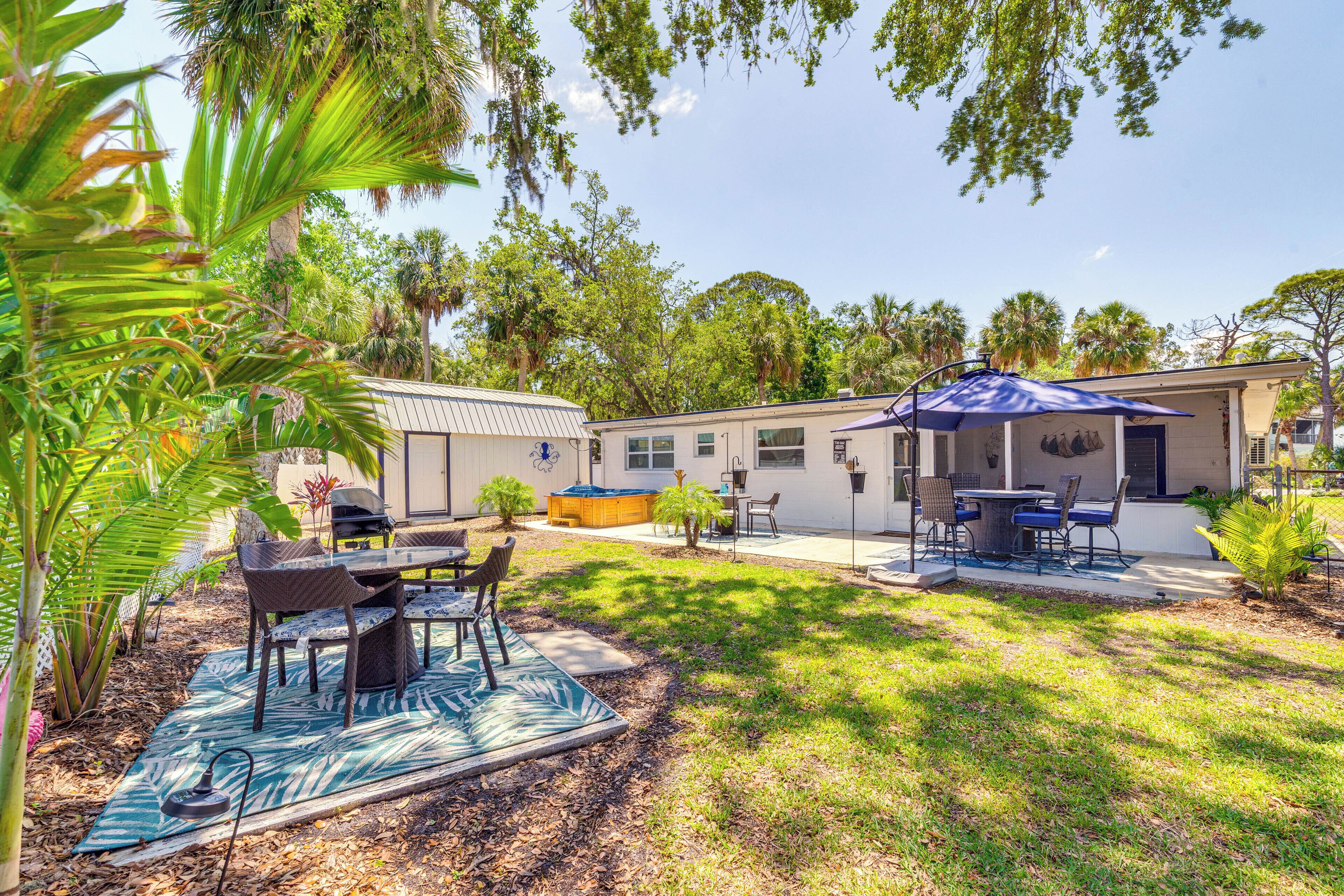 A backyard with a barbecue area, a covered patio, and a swimming pool.