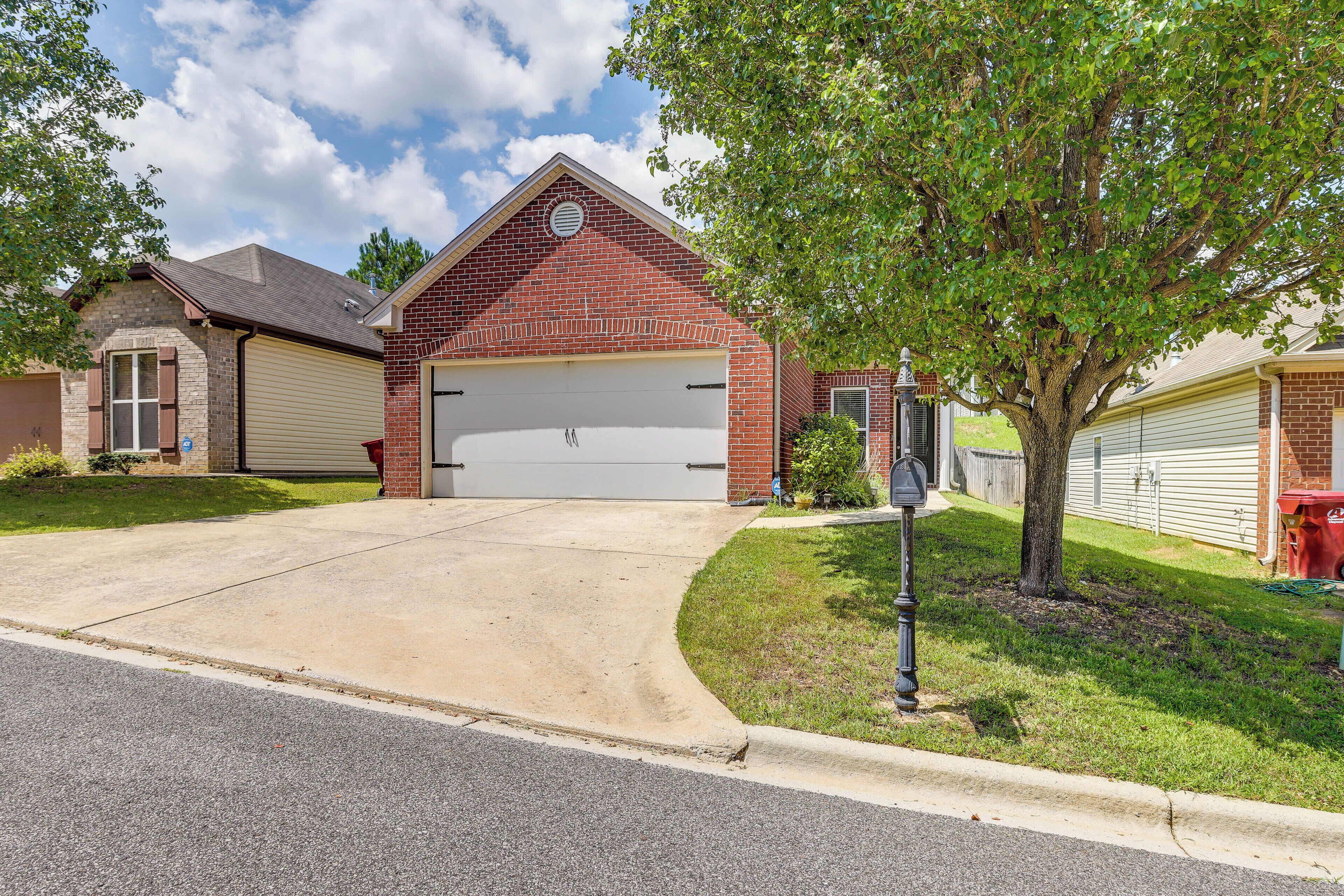 A residential house with a garage, a driveway, and a well-maintained lawn.