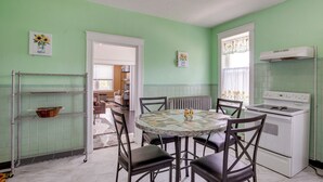A kitchen with a round table, four chairs, a white stove, and a radiator. - Walk to Restaurants: Cozy, Convenient Jennings Apt (Jennings)
