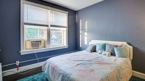 A bedroom with a large bed, a window with blinds, and a ceiling fan. - Walk to Restaurants: Cozy, Convenient Jennings Apt (Jennings)