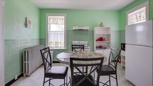 A kitchen with a round table, four chairs, a stove, a refrigerator, and a window with curtains. - Walk to Restaurants: Cozy, Convenient Jennings Apt (Jennings)