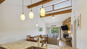 A kitchen with a granite countertop, stainless steel sink, and hanging pendant lights. - Lake Ozark Vacation Rental w/ Pool Access (Lake Ozark)