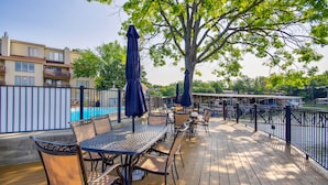 A wooden deck with outdoor seating, a pool, and a view of a residential area. - Lake Ozark Vacation Rental w/ Pool Access (Lake Ozark)