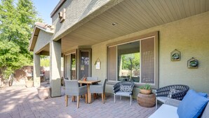 An outdoor patio with wicker furniture, potted plants, and a basketball hoop. - 'sunny V' Arizona Retreat w/ Private Pool & Patio (Surprise)
