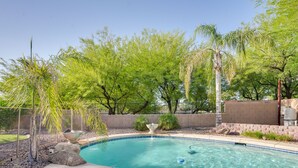A swimming pool with a fountain, surrounded by trees and a brick wall. - 'sunny V' Arizona Retreat w/ Private Pool & Patio (Surprise)