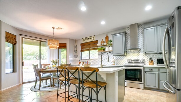 A modern kitchen with a central island, bar stools, and stainless steel appliances. - 'sunny V' Arizona Retreat w/ Private Pool & Patio (Surprise)