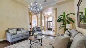A spacious living room with a chandelier, sofas, and a coffee table. - Luxe Yuma Home With Private Pool! (Yuma)
